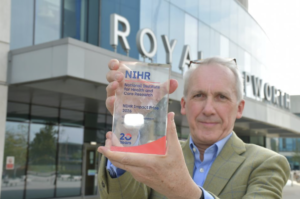 Professor Rintoul holding an NIHR Impact Prize 2026 'commended' trophy